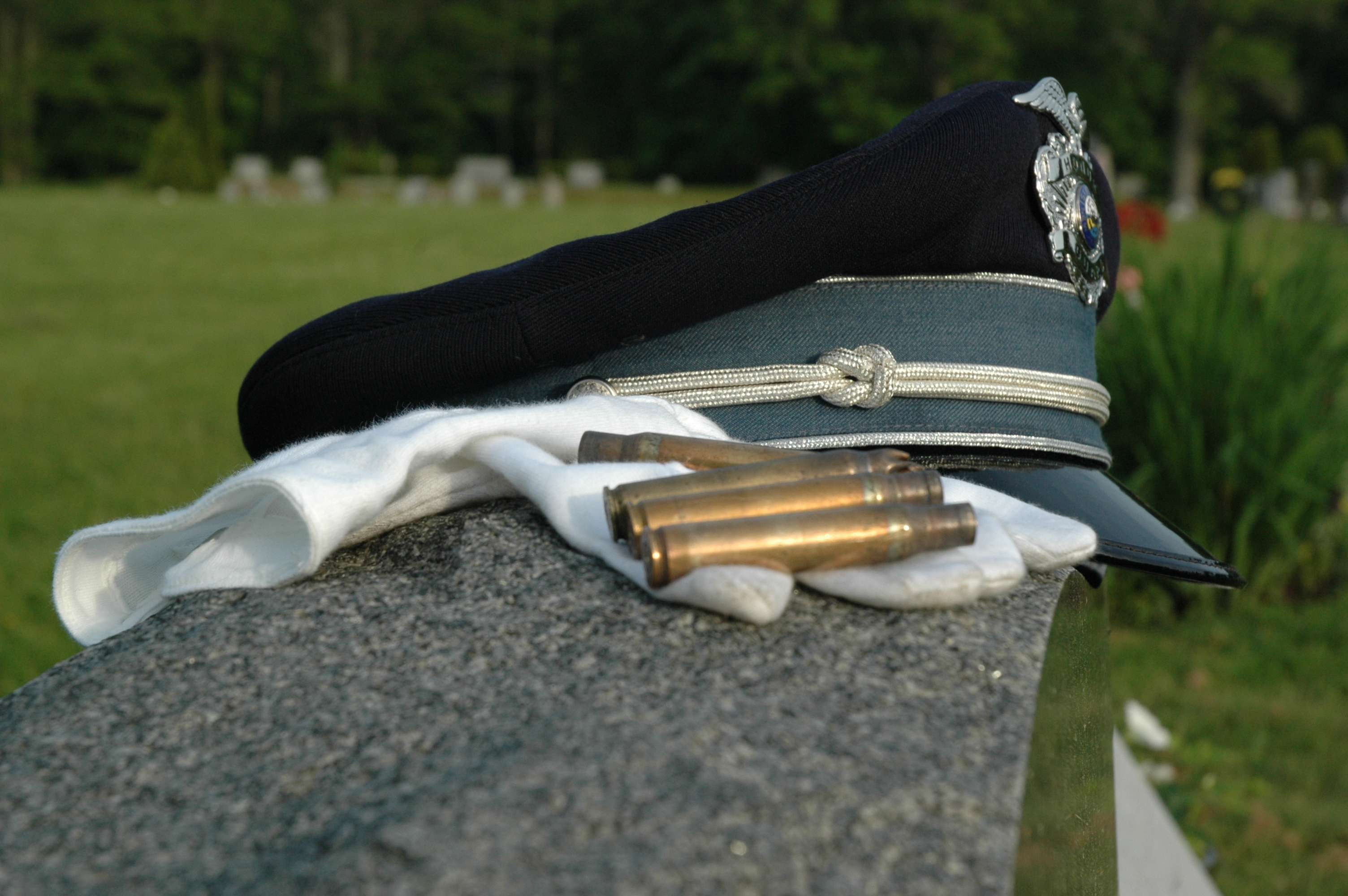 Honor Guard hat, glove and shell casings on grave