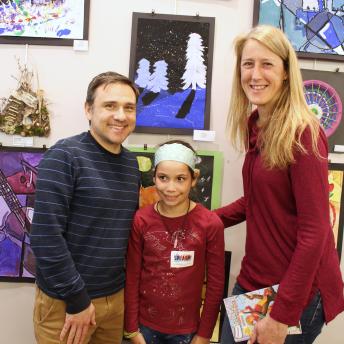 Parents with daughter in front of art exhibit
