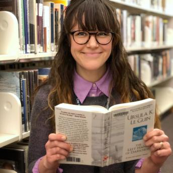 Library staff member with science fiction book