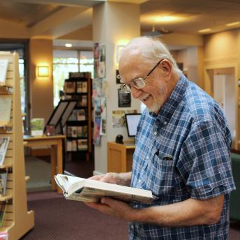 Older man reading in library lobby