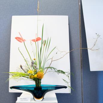 Multicolored flowers sticking up out of a blue vase