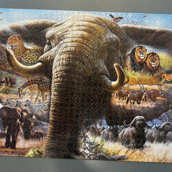 Giant elephant with giraffes, lions, leopards, gazelles and zebras surrounding it. 