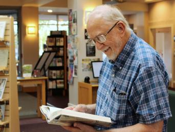 Older man reading in library lobby