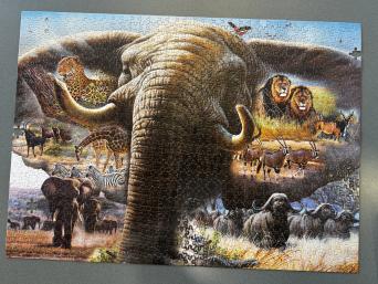 Giant elephant with giraffes, lions, leopards, gazelles and zebras surrounding it. 