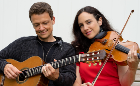 Dan Ascadi holding guitar and Leticia Prieto Alvarez holding Viola seated with white background