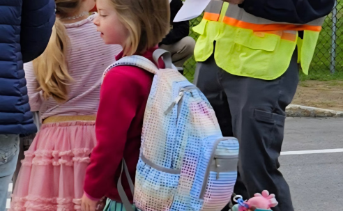 A crossing guard with students in the crosswalk