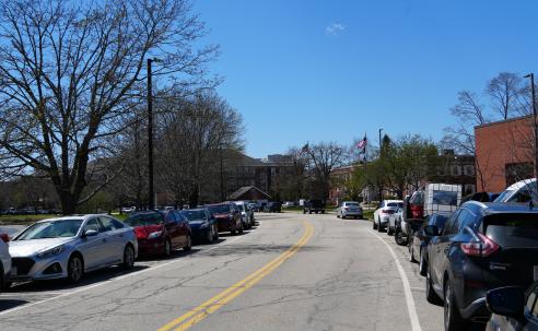 photo of cars parked along a street on a clear spring day